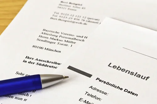 Ausgedruckter Lebenslauf auf einem Schreibtisch mit Kugelschreiber und Notizen.