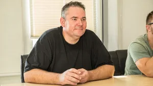Mann sitzt entspannt in einem Interview und spricht mit dem Gegenüber.