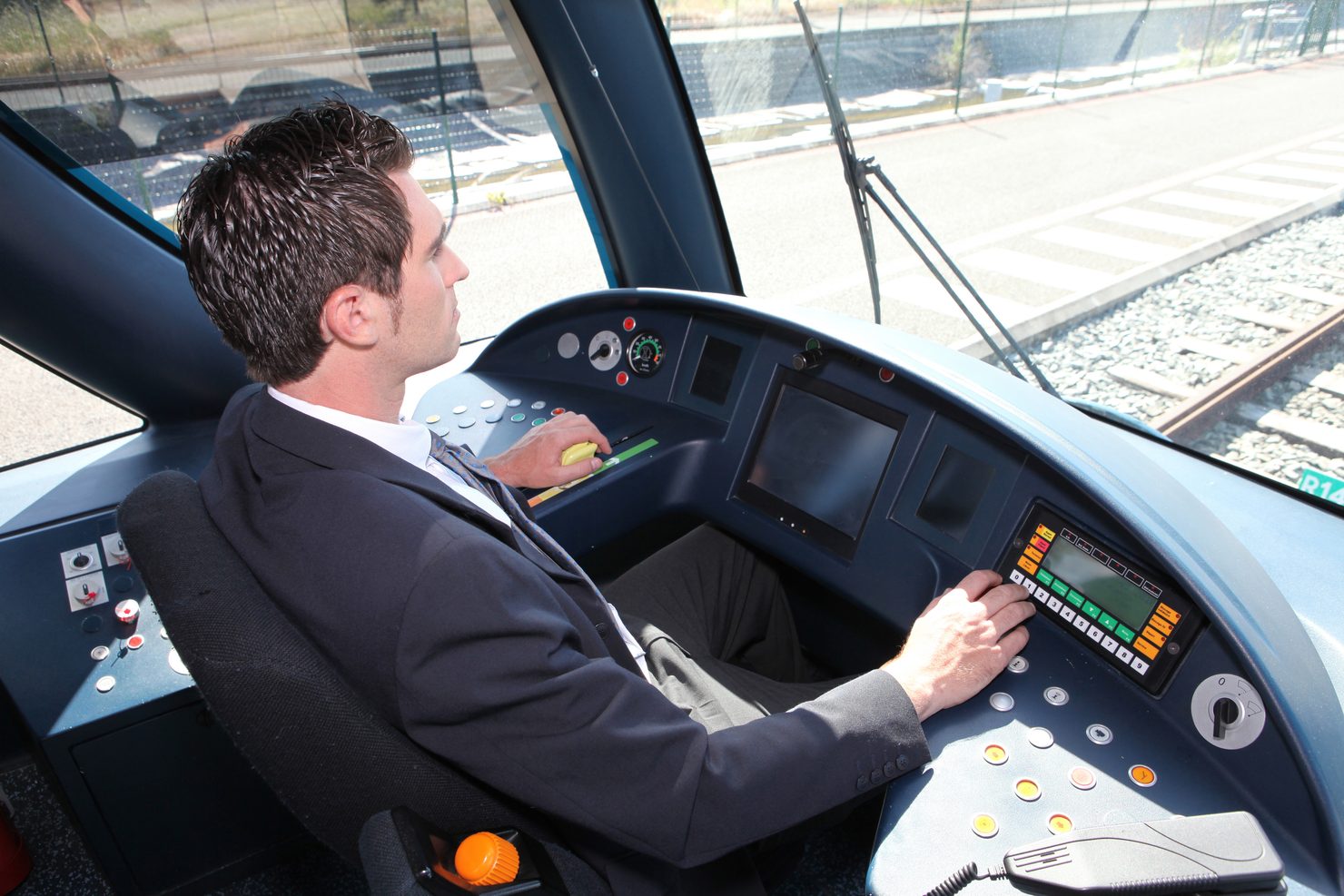 Eine Fachkraft im Fahrbetrieb in Ausbildung lernt den Triebwagen zu führen.